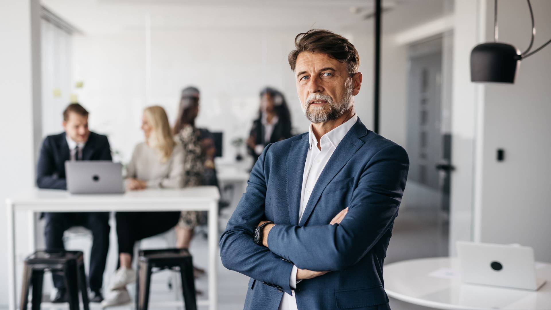Confident businessman standing with folded arms