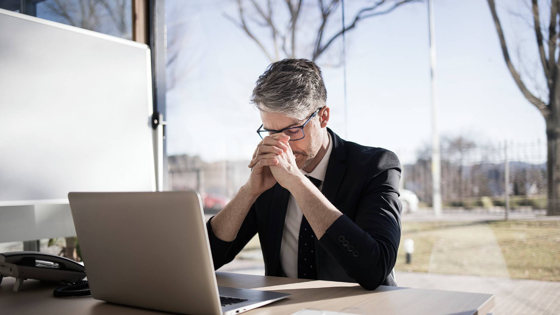 Man in suit thinking at desk.