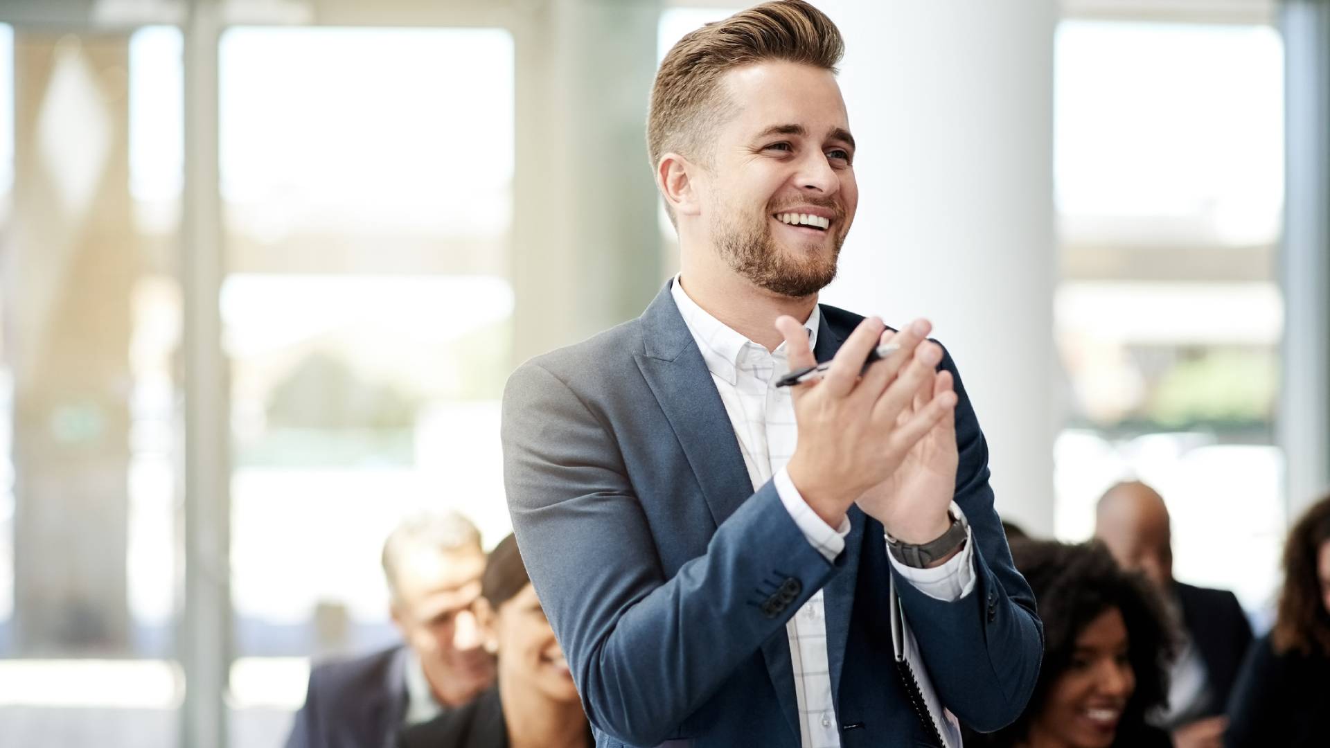 Man clapping enthusiastically at a business event.